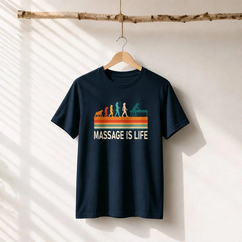 T-shirt bio Massage Is Life avec imprimé évolution rétro, suspendu sur cintre en bois, lumière naturelle