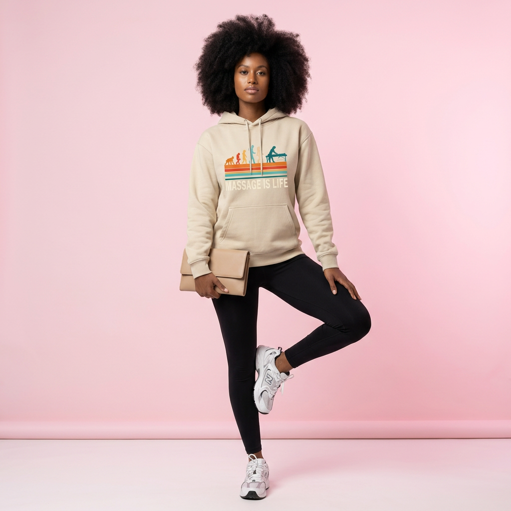 Sweat à capuche bio Massage Is Life, imprimé rétro, porté avec leggings noirs et sneakers blanches sur fond rose.