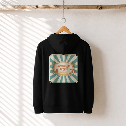 Sweat à capuche noir bio avec logo 'Massage Is Life' et design rétro, suspendu à un cintre en bois.