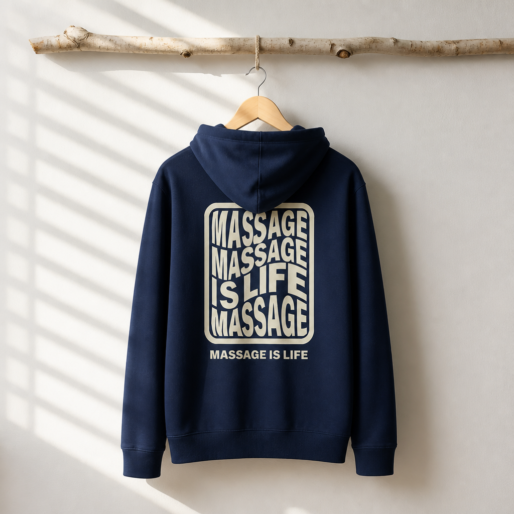 Sweat à capuche bio Massage Is Life, design graphique sur fond blanc, suspendu à une branche naturelle