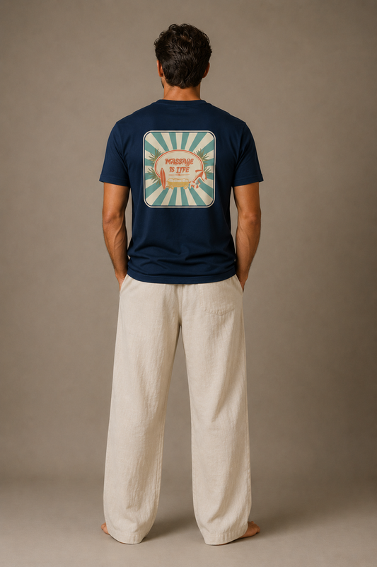 T-shirt bleu marine bio Massage Is Life dos imprimé soleil, porté avec pantalon lin beige