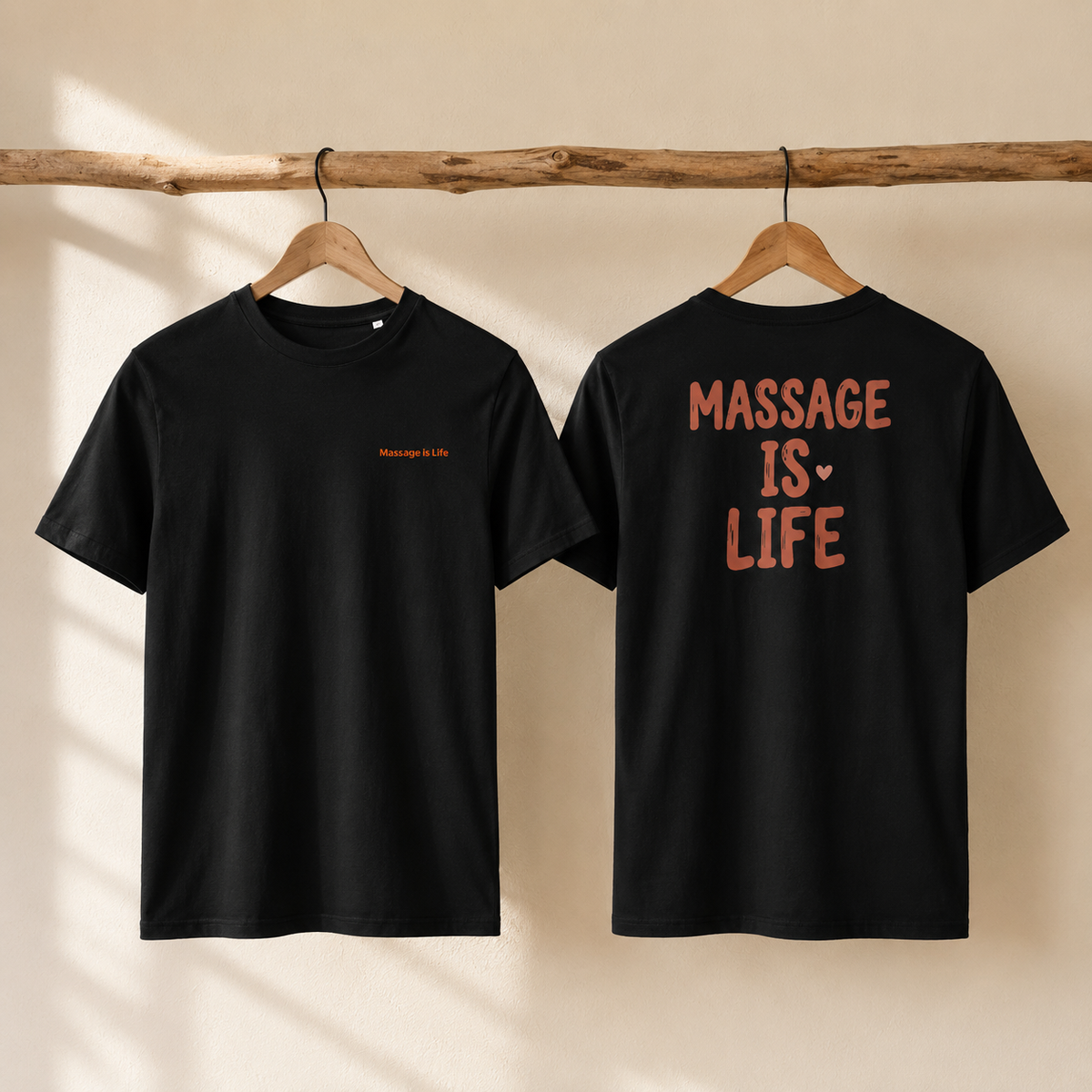 T-shirt noir bio Massage is Life, dos et devant, design bien-être, suspendu sur cintre bois