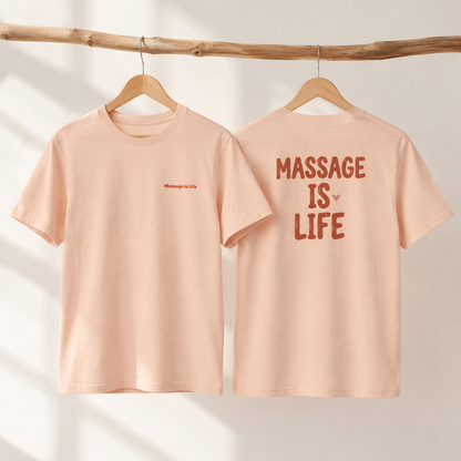 T-shirt bio rose pâle Massage is Life, dos et face, suspendu à une branche en bois