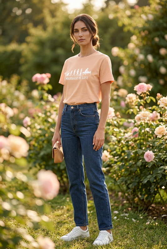 T-shirt bio Massage Is Life avec imprimé évolution, porté dans un jardin fleuri